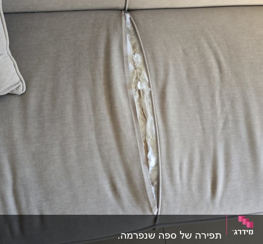 ספה עם קרע בחלק העליון וחומר מילוי חשוף